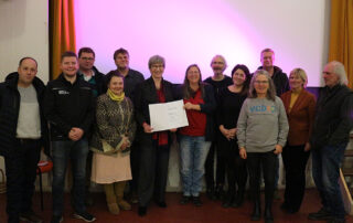 Gruppenbild vor der Kinoleinwand: Ministerin Kathrin Schneider und die Engagierten aus Brüssow